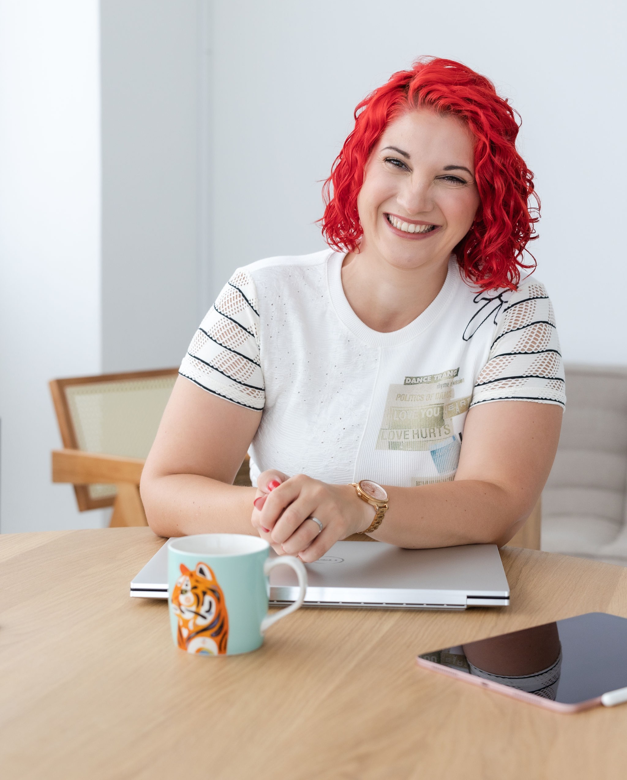 Lachende Vanessa in die Kamera schauend am Schreibtisch mit Arbeitsutensilien - Vanessa Bause Rock your Finances-cropped
